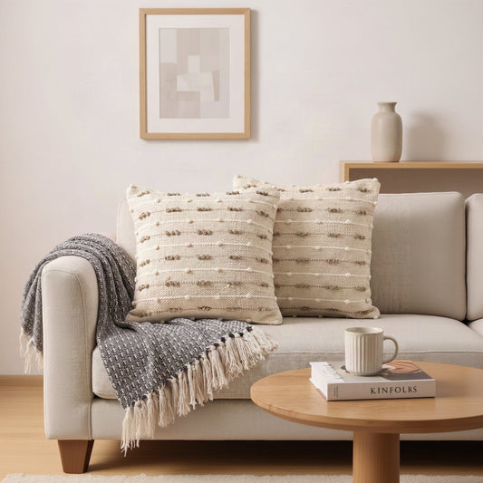 Kissenhülle Dune Lines in Natur und Taupe dekorativ auf einem hellen Sofa