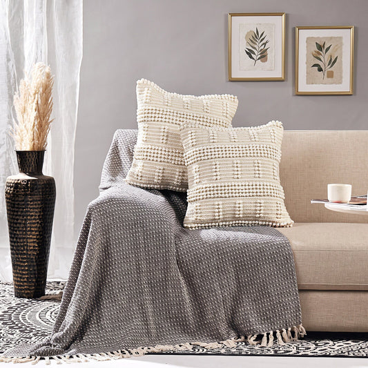 Handgefertigte Kissenhülle Ivory Grid in Creme auf einem hellen Sofa