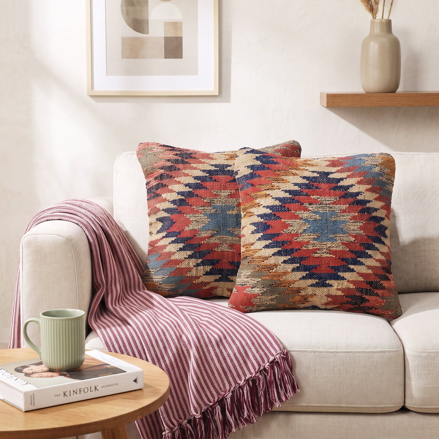 Kissenhülle Kilim Ember mit Zickzackmuster in warmen Farben auf einem Sofa