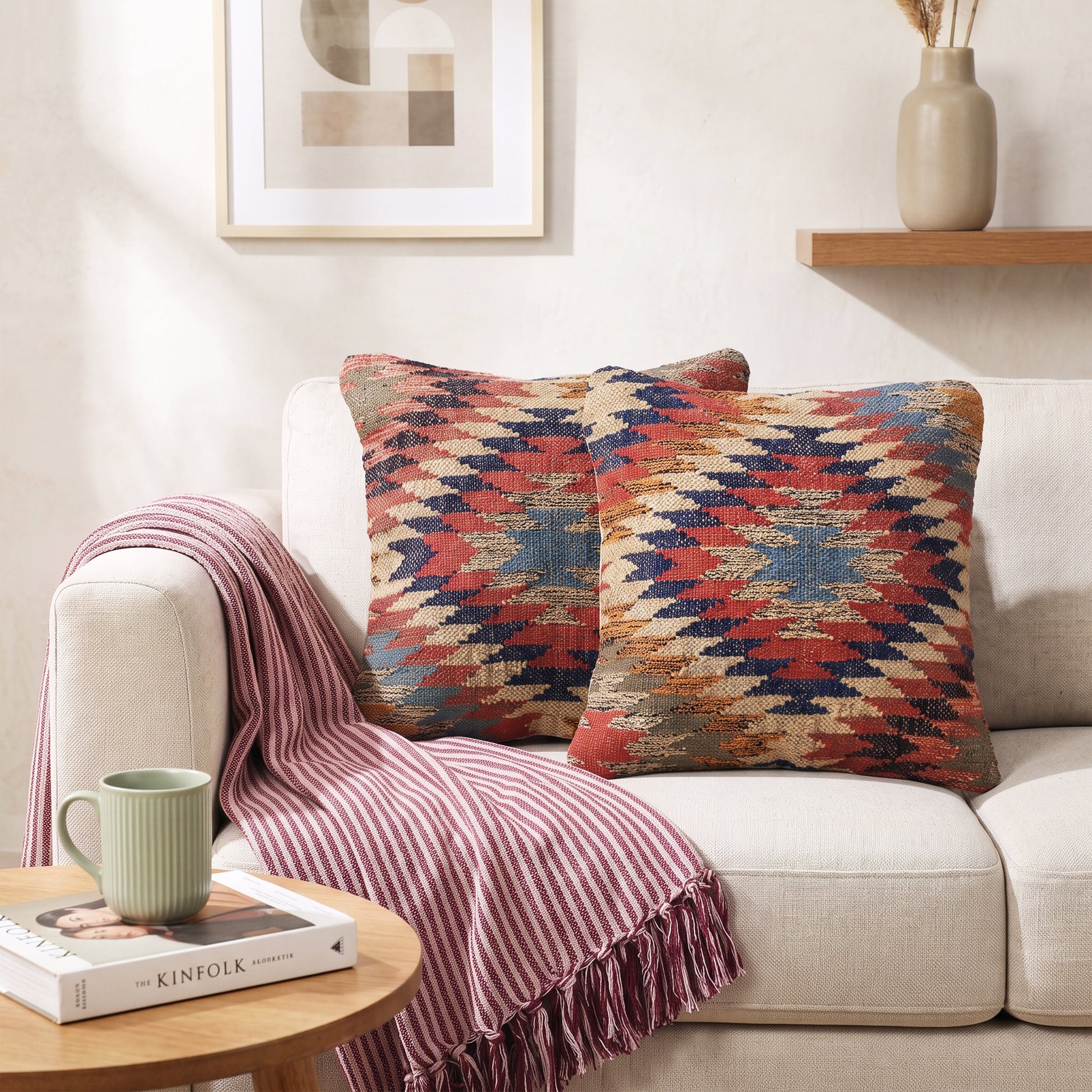Kissenhülle Kilim Ember mit Zickzackmuster in warmen Farben auf einem Sofa