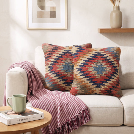 Kissenhülle Kilim Ember mit Zickzackmuster in warmen Farben auf einem Sofa